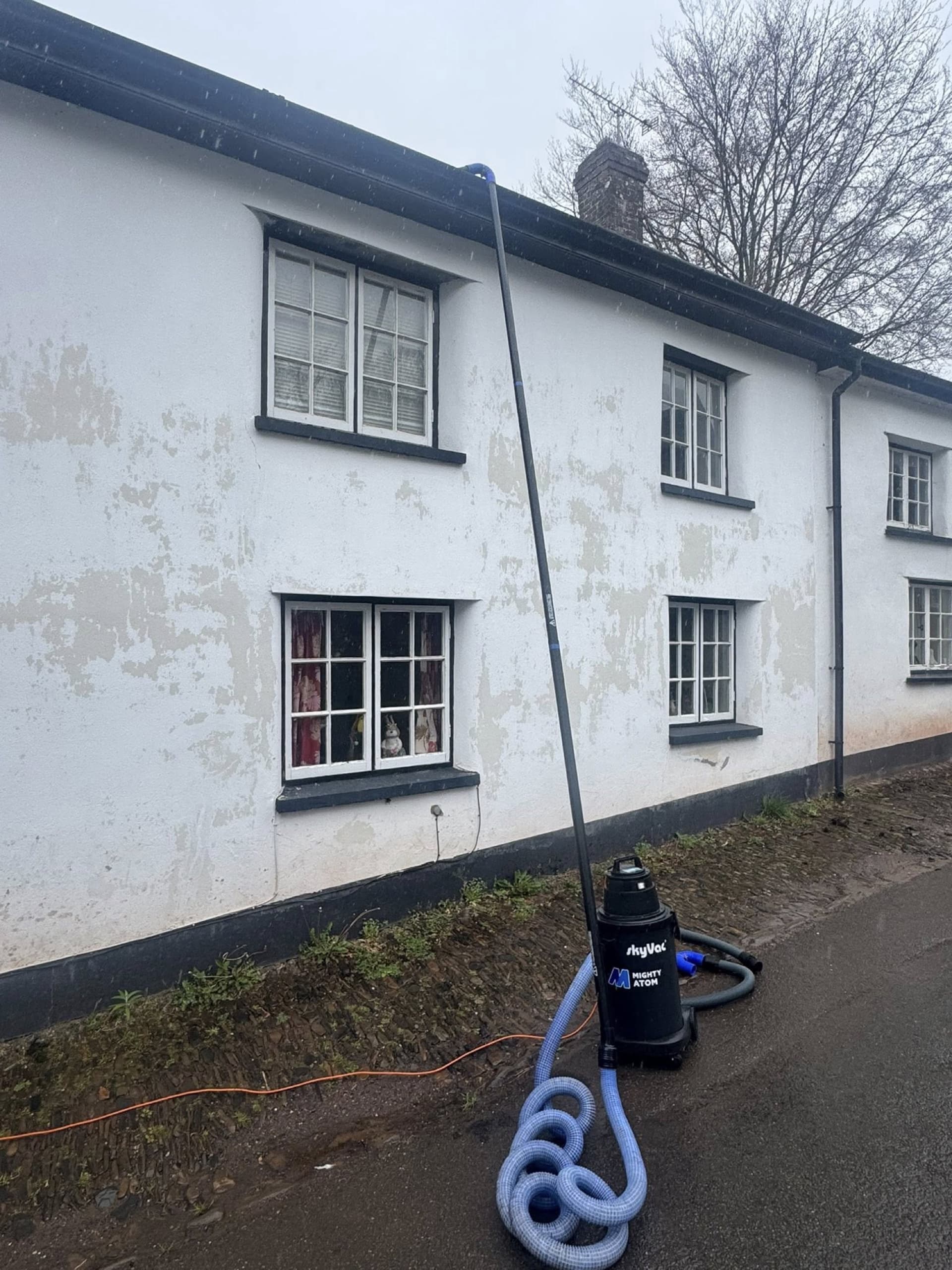 SkyVac Mighty Atom gutter cleaning on a Devon cottage exterior — exterior care and property maintenance work.